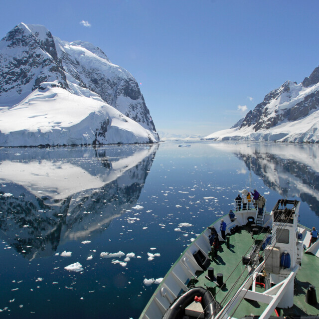 A small cruise ship makes passage through the Lemaire Channel in Antarctica
